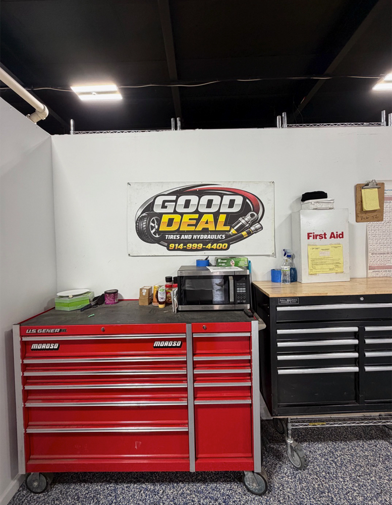 Side View & Sign inside of Good Deal Tires and Hydraulics shop